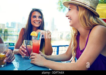 Femme, amis et rire avec des cocktails au bar pour une conversation amusante, blague ou mémoire sur les vacances de printemps. Personnes, groupe et happy hour avec chat, boissons Banque D'Images