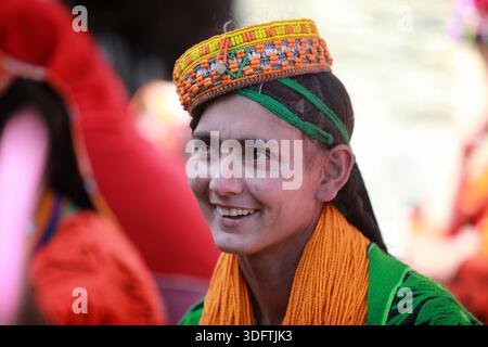 Kalash, Pakistan - 24 décembre 2025 : vue du sourire radieux d'une femme Kalash, encadré par sa coiffe traditionnelle vibrante et son châle, incarnant les riches Banque D'Images