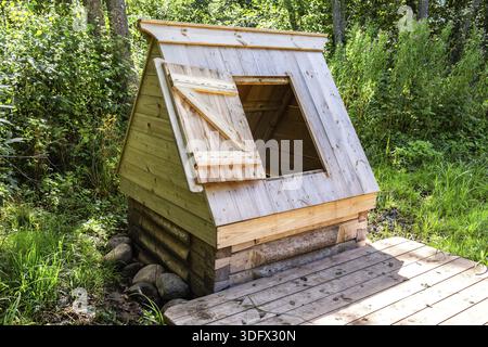 Nouveau puits d'eau en bois à la campagne en été ensoleillé jour Banque D'Images