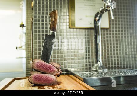 Belle photo de poitrine de boeuf (extrémité de pointe de poitrine). Viande coupée avec couteau en acier forgé Damas style Arkansas Breeze Banque D'Images