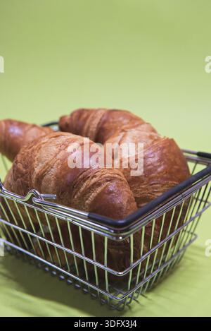Macro-pousse de croissants dans le panier sur fond de menthe verte Banque D'Images