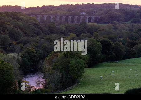 Chirk Viaduc dans la campagne entre l'Angleterre et le pays de Galles au lever du soleil avec la rivière Dee reflétant les couleurs dorées en automne Banque D'Images