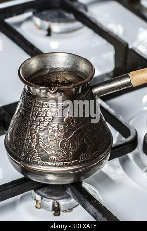 Cafetière en cuivre sur la cuisinière à gaz. La cuisine maison Banque D'Images