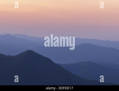 Silhouettes des collines de montagne après le coucher du soleil. cascade de montagne Banque D'Images
