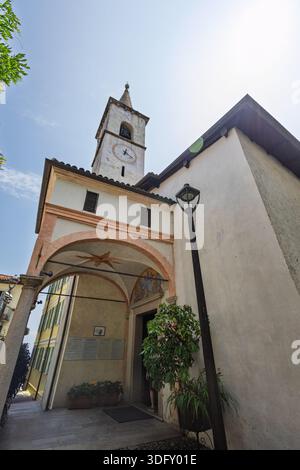ISOLA DEI PESCATORI, ITALIE, 06.21.2025 :Une rue européenne ensoleillée dispose d'une tour d'horloge historique, d'une entrée voûtée et d'une façade accueillante. PE Banque D'Images