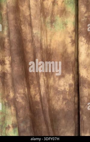 Texture abstraite de tissu brun et olive tie-dye avec des plis de draperie doux. Toile de fond textile marbré professionnelle Banque D'Images
