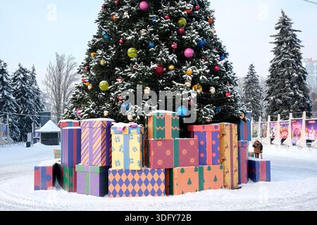 Des cadeaux brillamment enveloppés entourent un sapin de Noël joliment décoré en hiver. Kiev, Ukraine, Expocenter de l'Ukraine. 14 janvier 2026. Banque D'Images