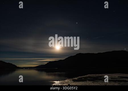 Une vue de la Lune projetant un arc-en-lune sur Ullswater dans le Lake District anglais Banque D'Images