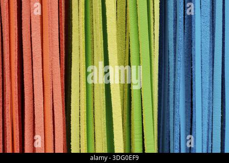 Texture découpée gros plan sur plusieurs bracelets en cuir multicolores orange, vert et bleu, district de Bunkyo, Japon Banque D'Images