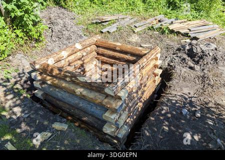 Nouvelle construction de puits d'eau en bois dans village russe en été Banque D'Images
