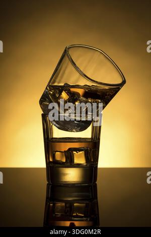 Deux verres à whisky rétroéclairés avec glaçon Banque D'Images