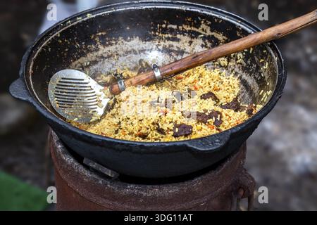 La cuisson pilaf ouzbek traditionnel dans un grand chaudron à l'extérieur Banque D'Images