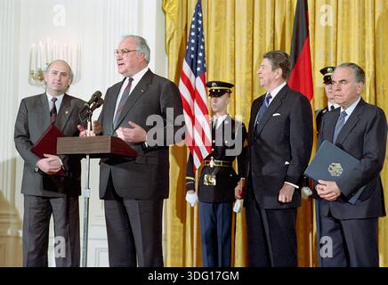 Le président américain Ronald Reagan lors d'une visite de travail du chancelier Helmut Kohl de la République fédérale d'Allemagne et de leur échange de remarques de départ avec Charles Wick et Harry Obst, White House East Room, Washington, DC, USA, le président Ronald Reagan White House Photographic Office, 19 février 1988, Banque D'Images