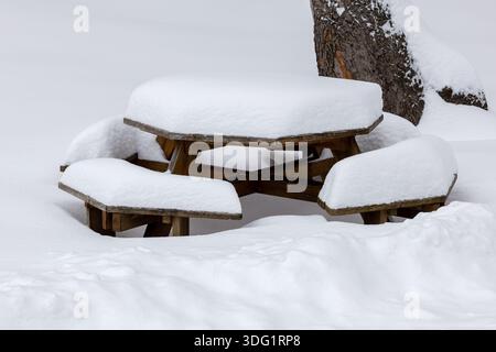 Table de pique-nique en bois recouverte d'une épaisse couche de neige blanche fraîche Banque D'Images