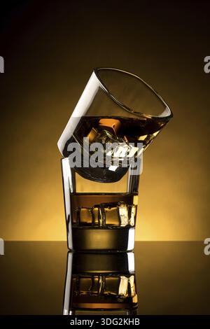 Deux verres à whisky rétroéclairés avec glaçon Banque D'Images
