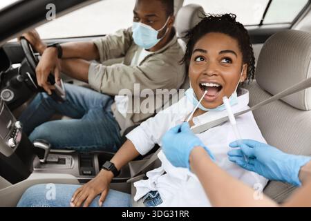 Black Woman testé pour Covid-19 assis en mode Auto Banque D'Images