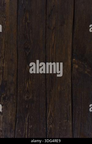 Des planches de bois brun foncé forment un mur. Atmosphère sombre. Fond en bois naturel. Banque D'Images