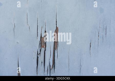 Surface peinte en bleu altérée avec des fissures qui s'écaillent révélant du bois vieilli en dessous Banque D'Images