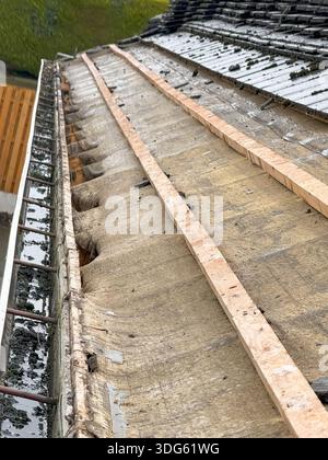 Toit de maison endommagé avec des bardeaux manquants après l'ouragan. Conséquences des catastrophes naturelles. réparation de toit sur une maison résidentielle Banque D'Images