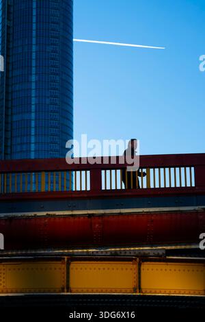 Un banlieue marche sur un London Bridge au coucher du soleil Banque D'Images