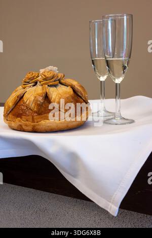 réception de mariage avec deux flûtes élégantes de champagne pétillant accompagnées d'un pain traditionnel joliment décoré. Cette cérémonie Banque D'Images