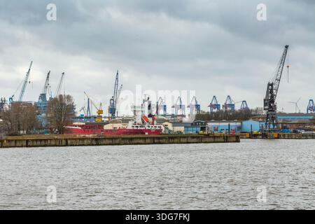 Hambourg Allemagne - 21 février 2020. Le cargo rouge Swalk a accosté à un chantier naval. Grues portuaires industrielles et infrastructures dans le bac Banque D'Images