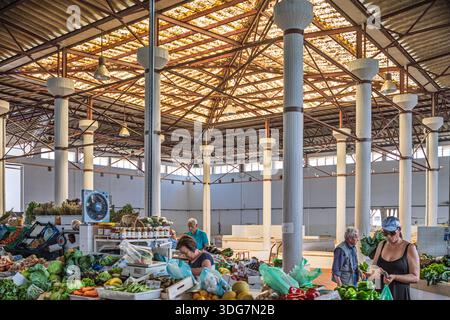 Les gens magasinent au marché Vila Real de Santo Antonio, parcourant les produits frais sous le toit architectural distinctif du marché en Algarve, Portuga Banque D'Images