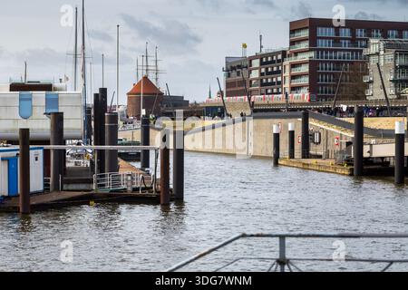 Hambourg, Allemagne – 21 février 2020 : les gens marchent le long de la promenade moderne de la rivière Niederhafen conçue par Zaha Hadid près de Baumwall avec vue sur le port et le rouge Banque D'Images