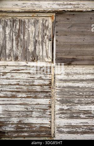 Image abstraite de panneaux en bois altérés sur un ancien abri de jardin avec des panneaux horizontaux et verticaux formant des formes et des motifs, textures sur bois. Banque D'Images