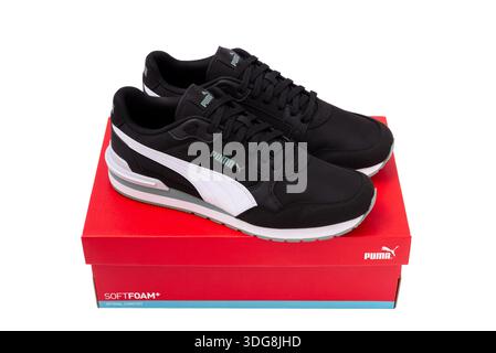 Obrenovac, Serbie - 11 juillet 2025 : élégantes baskets Puma noires sur boîte à chaussures Puma rouge isolé sur fond blanc. Banque D'Images