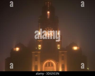 Liverpool, Royaume-Uni. 16 janvier 2026. Météo britannique. Une épaisse couverture de brouillard a commencé à s'installer sur Merseyside ce soir. Un avertissement météorologique jaune a été mis en place avec du brouillard qui devrait affecter l'ensemble du Merseyside. Cette image aérienne atmosphérique montre le Royal Liver Building enveloppé dans une couverture dense de brouillard nocturne. Crédit : Liverpool Live News/Alamy Live News Banque D'Images