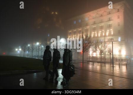 Liverpool, Royaume-Uni. 16 janvier 2026. Météo britannique. Une épaisse couverture de brouillard a commencé à s'installer sur Merseyside ce soir. Un avertissement météorologique jaune a été mis en place avec du brouillard qui devrait affecter l'ensemble du Merseyside. Cette image d'ambiance montre la statue des Beatles avec le Royal Liver Building et le Cunard Building entourés d'une couverture dense de brouillard nocturne. Crédit : Liverpool Live News/Alamy Live News Banque D'Images
