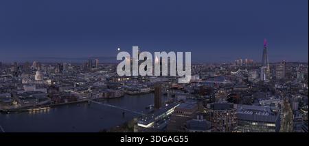 Vue aérienne de la ligne d'horizon de Londres brille par une lumière chaude contre le bleu frais du ciel crépusculaire, avec le Shard debout près de la rivière, Londres, Banque D'Images