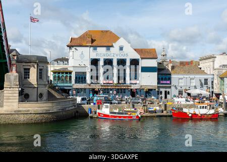 Weymouth, Royaume-Uni - 5 septembre 2025 : drapeau de l'Union Jack survolant le Control Pavilion sur le Town Bridge à côté de bateaux de pêche amarrés dans le port. Banque D'Images