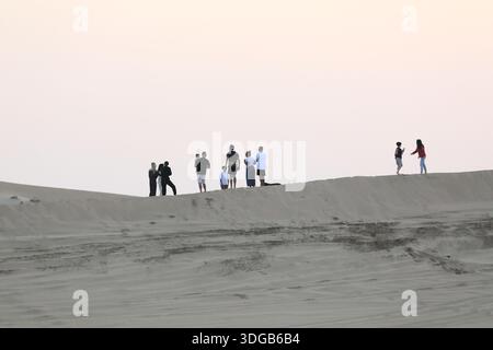 Des gens debout au sommet d'une dune de sable Banque D'Images