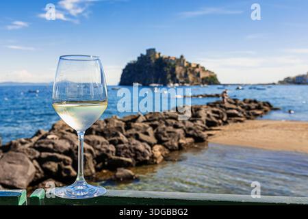 Un verre de vin blanc accompagne le panorama suggestif d'Ischia Ponte Banque D'Images