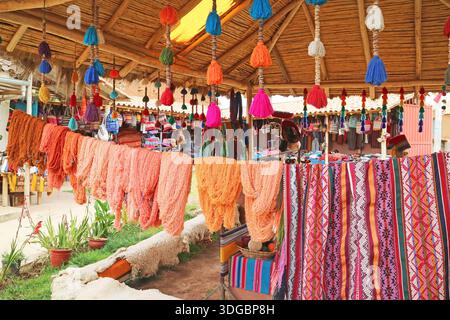 Des fils de laine teints naturels multicolores péruviens accrochés au village textile des Andes de Chinchero, région de Cuzco, Pérou, Amérique du Sud Banque D'Images