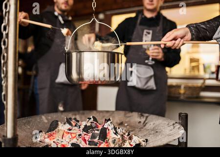 Préparation de fondue au fromage suisse dans une atmosphère traditionnelle Banque D'Images