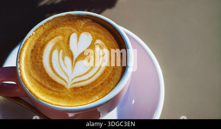 Tasse de latte avec motif coeur sur soucoupe à la lumière du jour naturelle avec espace pour copie Banque D'Images