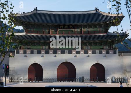 Vue de face de la porte de Gwanghwamun avec l'architecture traditionnelle coréenne du palais, base en pierre, structure en bois, toit en tuiles et trois entrées voûtées Banque D'Images