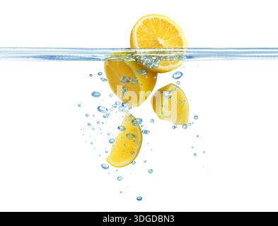 Citrons frais tombant dans l'eau sur fond blanc Banque D'Images