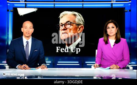 Capture d'écran des co-présentateurs de PBS NewsHour Geoff Bennett et Amna Nawaz et du président de la réserve fédérale Jerome Powell. Banque D'Images