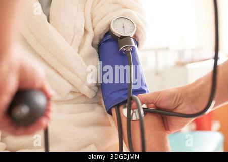 médecin féminin mesurant la pression de la patiente en gros plan hospitalier, foyer sélectif. Banque D'Images