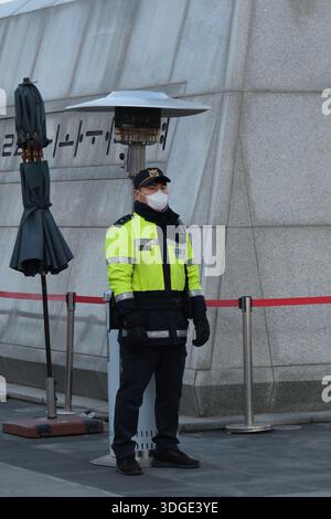 Séoul, Corée du Sud : officier de police coréen portant un masque et un uniforme d'hiver gardant la zone publique près des bâtiments gouvernementaux Banque D'Images