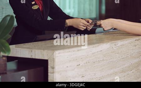 Deux mains échangent une carte de visite et des transactions, mettant en évidence le réseautage, le contact professionnel et la collaboration entre les individus. ECHANGE personnel Banque D'Images