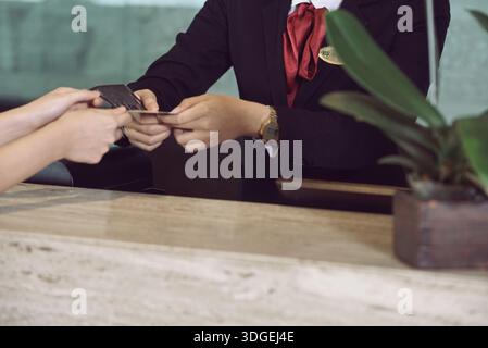 Deux mains échangent une carte de visite et des transactions, mettant en évidence le réseautage, le contact professionnel et la collaboration entre les individus. ECHANGE personnel Banque D'Images