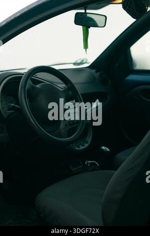 Intérieur d'un véhicule avec un volant et un tableau de bord, capturant l'atmosphère calme Banque D'Images