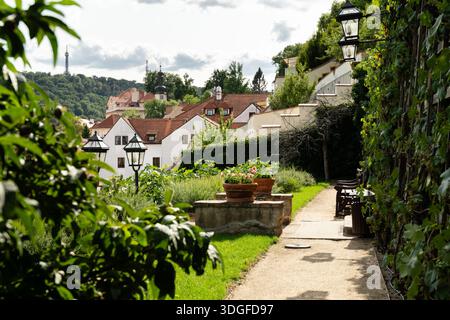 Une vue depuis les jardins du palais en terrasses en contrebas du château de Prague, avec la tour de guet Petřín visible sur la colline au-dessus des toits de la petite ville. Banque D'Images