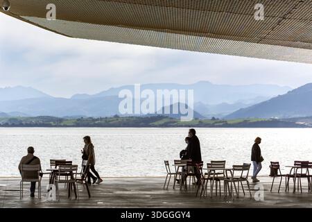 Santander, Espagne – 20 novembre 2021 : les gens marchent dans des directions différentes et assis à des tables sur la promenade du front de mer sous le toit moderne du CEN Banque D'Images