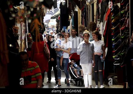 Les gens se promènent dans une ruelle étroite avec des boutiques traditionnelles, Fès, Fès el Bali, Maroc Banque D'Images